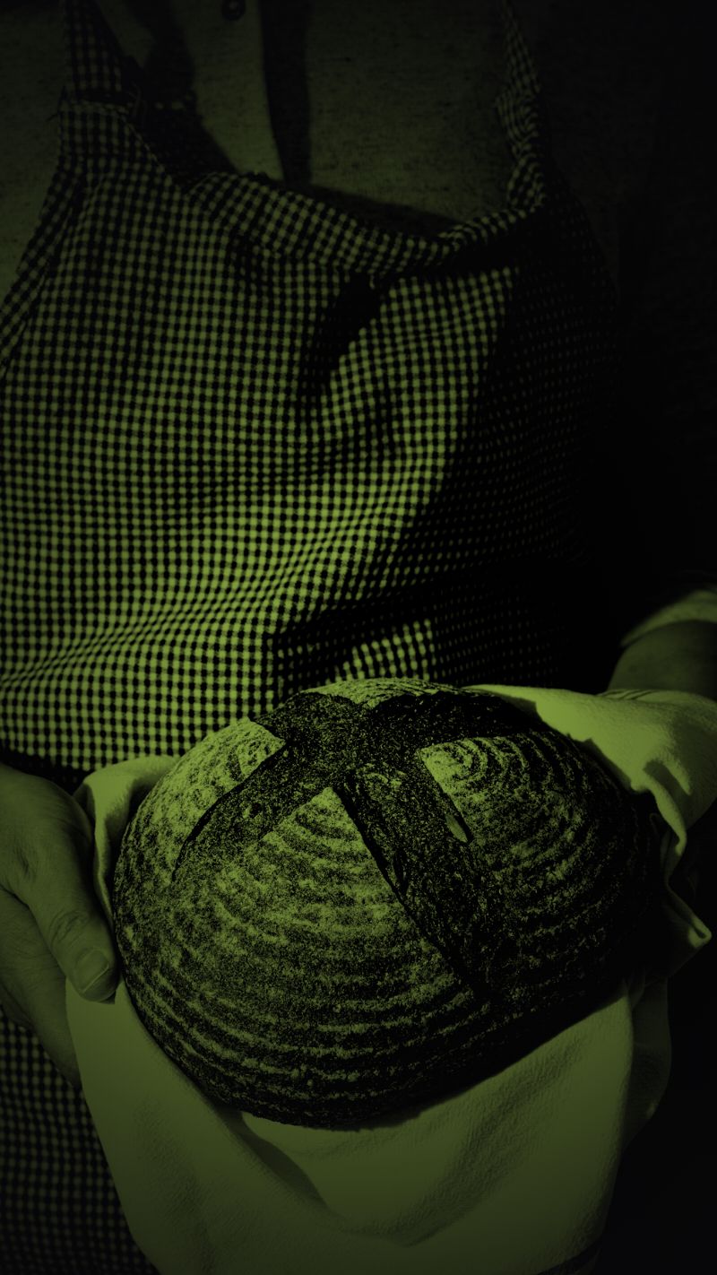 Mãos segurando um pão dentro do próprio negócio, a cena que vira anúncio